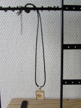 Très joli pendentif présentant une feuille d'or sous verre;