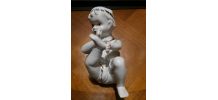 bébé couché  piano en porcelaine
