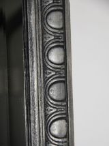 Miroir ancien en bois sculpté, patiné noir et argent