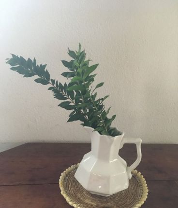 Dessous de plat en rotin et coquillages en bordure.