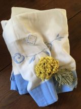 Drap blanc à la bordure bleue lavande.