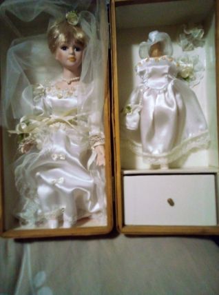 vends une ancienne poupée en porcelaine dans un robe de mari