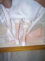 vends une ancienne poupée en porcelaine dans un robe de mari