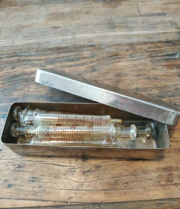 Seringues,pistons verre dans boîte inox