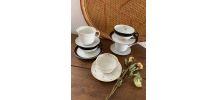 5 tasses dépareillées en blanc, noir et doré.