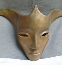 Masque décoratif en terre cuite patinée.