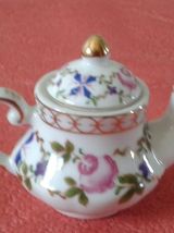 Théière et ses deux tasses miniature sur un plateau.