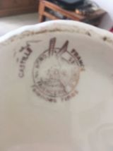 Cafetière porcelaine à la bordure fleurie.