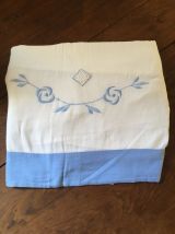 Drap blanc à la bordure bleue lavande.