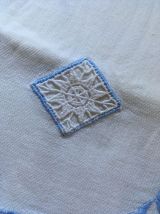 Drap blanc à la bordure bleue lavande.