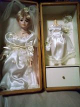 vends une ancienne poupée en porcelaine dans un robe de mari
