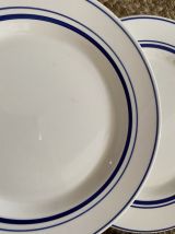 5 assiettes plates aux liserés bleus.