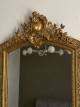 Miroir doré fin 19ème avec fronton décoré. 125x70.