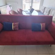 Canapé-lit en velour rouge en très bon état