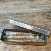Seringues,pistons verre dans boîte inox
