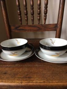 Duo de tasses blanches noires et motifs dorés en porcelaine.
