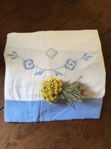 Drap blanc à la bordure bleue lavande.