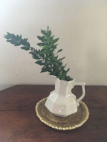 Dessous de plat en rotin et coquillages en bordure.