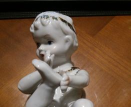 bébé couché  piano en porcelaine