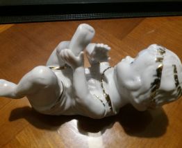 bébé couché  piano en porcelaine