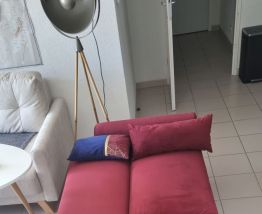 Canapé-lit en velour rouge en très bon état