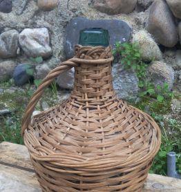 Dame jeanne dans son support en osier tréssé