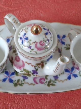 Théière et ses deux tasses miniature sur un plateau.