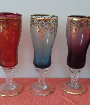 Cinq flûtes à champagne en verre coloré.